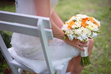 Photo for Bride holding bridal bouquet on her knees. - Royalty Free Image