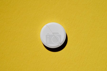 Photo for Pharmacy health care concept. Close up of white tablet on yellow background. - Royalty Free Image