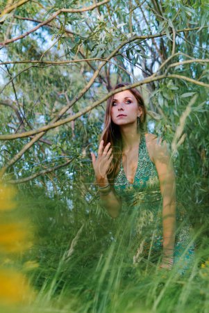 Foto de Retrato al aire libre de la joven hermosa mujer con el pelo largo contra la naturaleza verde - Imagen libre de derechos