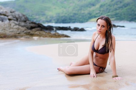 Téléchargez les photos : Vacances sur la mer. Joyeux jeune femme profitant du bronzage sur la plage de sable. - en image libre de droit