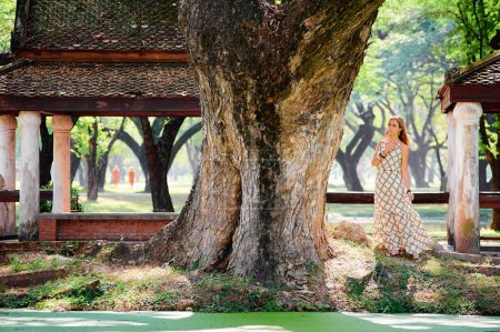 Foto de Mujer joven bajo el gran árbol en el antiguo parque cerca de la alcoba - Imagen libre de derechos