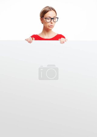 Photo for Your text here. Studio portrait of pretty young woman looking at empty blank board with copy space with expression of surprise. - Royalty Free Image