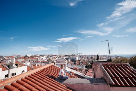Téléchargez les photos : Voyager au Portugal. Jeune voyageuse profitant de la vieille ville de Lisbonne vue sur le toit carrelé rouge. - en image libre de droit