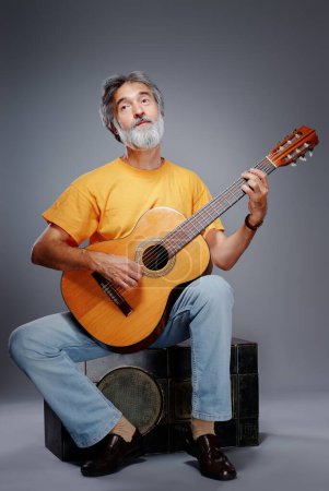 Foto de Hombre barbudo envejecido con una guitarra acústica - Imagen libre de derechos