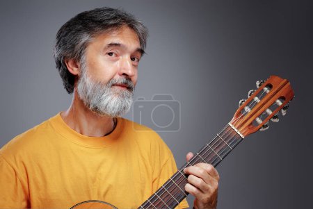 Téléchargez les photos : Homme barbu âgé avec une guitare acoustique - en image libre de droit