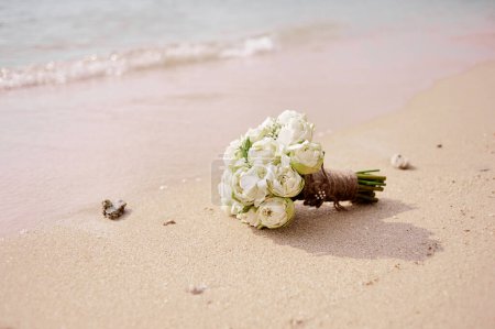 Foto de Hermoso ramo nupcial de lotos blancos y orquídeas en una playa tropical
. - Imagen libre de derechos