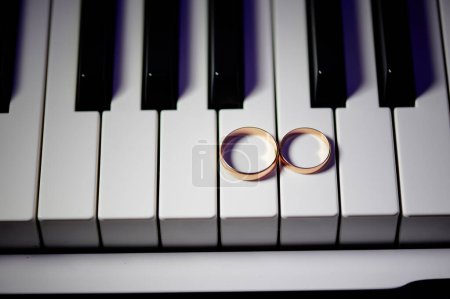 Téléchargez les photos : Anneaux d'or de mariage sur les touches piano - en image libre de droit