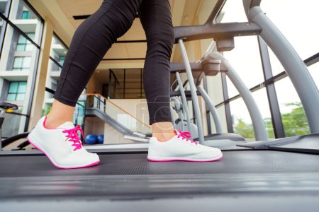 Foto de Concepto deportivo. Primer plano de correr pies femeninos en zapatillas de deporte en el gimnasio. - Imagen libre de derechos