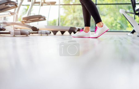Foto de Concepto deportivo. Primer plano de pies femeninos en zapatillas de deporte en el gimnasio. - Imagen libre de derechos