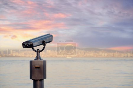Téléchargez les photos : Coin Opéré spectateur binoculaire à côté de la promenade au bord de l'eau donnant sur la baie et la ville. - en image libre de droit