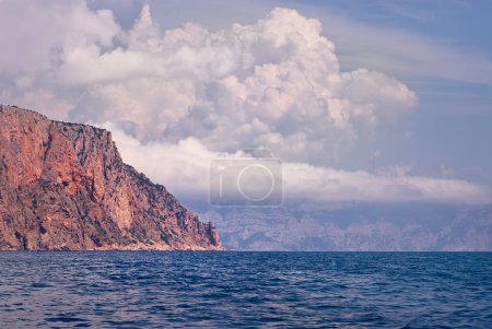 Foto de Roca solitaria con nubes en el mar - Imagen libre de derechos