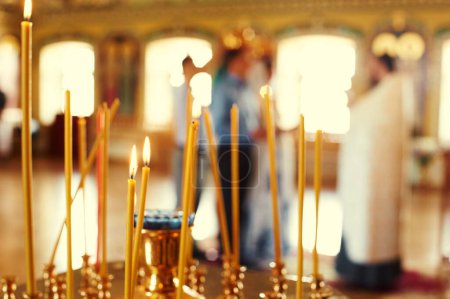 Foto de Velas de iglesia ardiendo en un candelero dorado en un templo. - Imagen libre de derechos