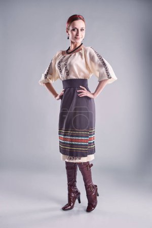 Téléchargez les photos : Jeune femme ukrainienne posant en tissu traditionnel à la mode sur fond gris. - en image libre de droit
