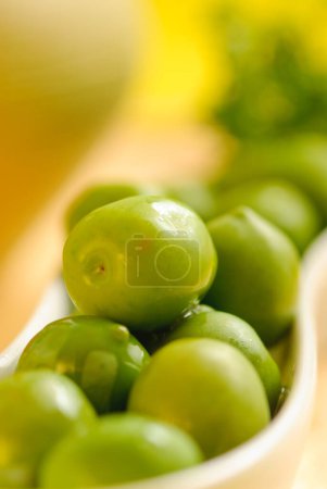 Green olives lay in white plate