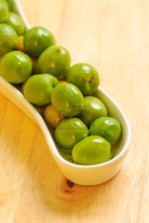 Olives vertes disposées dans une assiette blanche