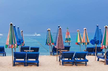 Téléchargez les photos : Vacances tropicales. Belle plage de sable avec chaises longues et parasols. Ciel nuageux. - en image libre de droit