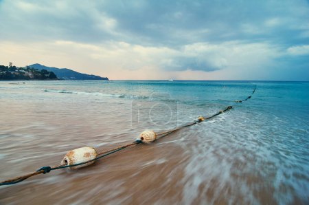 Téléchargez les photos : Bouys sur le marqueur de corde sur la plage de sable. Beau paysage marin avec ciel nuageux. - en image libre de droit