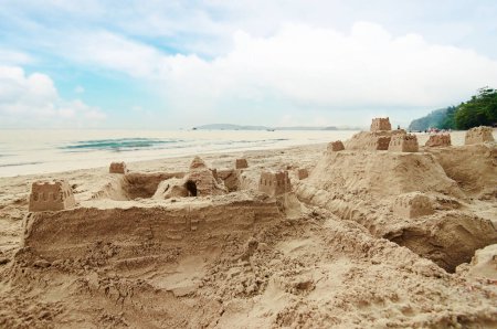 Téléchargez les photos : Grand château de sable sur la plage de mer. - en image libre de droit