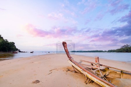 Old wooden longtail boat covered by sand. Travel by Thailand. Beautiful landscape with tropical sea beach.