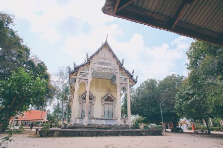 Téléchargez les photos : Temple bouddhiste blanc avec des fenêtres et un toit richement décorés. Art religieux traditionnel, architecture de Thaïlande. - en image libre de droit