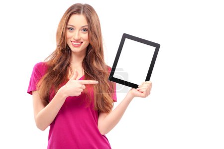 Foto de Copia espacio en su tableta. Joven mujer caucásica confiada señalando su tableta digital y sonriendo mientras está de pie aislada en blanco - Imagen libre de derechos