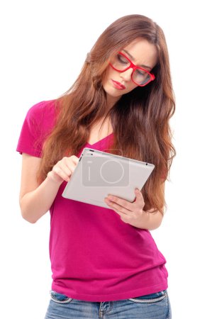 Foto de Trabajando en su nueva tableta. Hermosa chica con el pelo largo de trabajo en la tableta digital, mientras que de pie sobre fondo blanco - Imagen libre de derechos