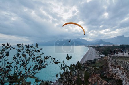 Téléchargez les photos : Parapente sur la plage, activités de loisirs. Belle vue sur la ville d'Antalya avec montagnes et baie maritime. Turquie. - en image libre de droit