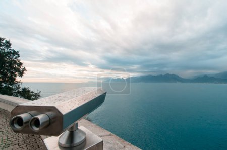Téléchargez les photos : Coin Opéré spectateur binoculaire à côté de la promenade au bord de l'eau à Antalya donnant sur la baie et la ville
. - en image libre de droit
