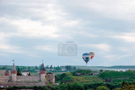 Photo for Beautiful sunset summer landscape with ancient castle and balloons in the sky. Kamianets-podilskyi, Ukraine. - Royalty Free Image