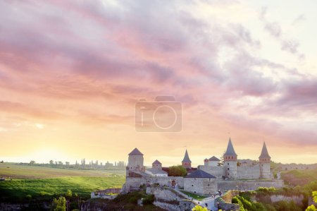 Téléchargez les photos : Visites guidées. Beau paysage avec château médiéval et ciel nuageux. Kamianets-podilskyi, Ukraine. - en image libre de droit