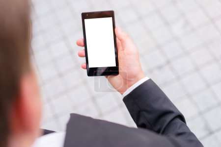 Foto de Copia espacio en la pantalla. Primer plano de la mano del hombre de negocios con un smartphone al aire libre. - Imagen libre de derechos