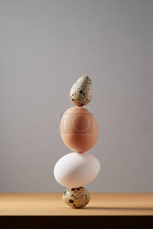 Téléchargez les photos : Cairn d'œufs sur fond blanc, tour d'œufs, harmonie et équilibre de simplicité, sculptures zen. - en image libre de droit