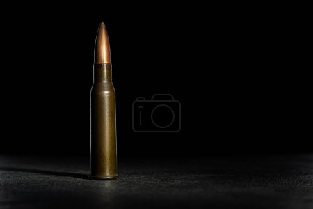 Photo for Rifle bullet long cartridge on black background. Army or hunting weapon shot object, violence and danger symbol. - Royalty Free Image