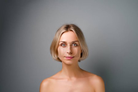 Natural beauty. Blonde woman with healthy skin.  No makeup. Grey background.