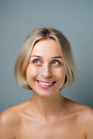 Natural beauty. Blonde woman with healthy skin.  No makeup. Grey background.