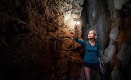Junge Frau erkundet eine im Berg gegrabene Höhle.