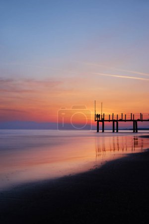 Téléchargez les photos : Beau coucher de soleil sur la plage de mer. Le ciel se reflète sur l'eau. - en image libre de droit