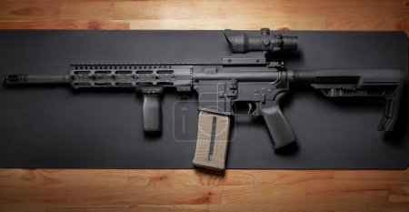 AR-15 rifle on wooden table.