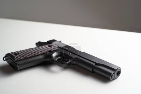 Foto de Tiro blanco y negro de pistola negra grande sobre la mesa - Imagen libre de derechos