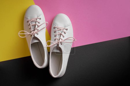 Photo for Pair of white gumshoes on colorful background. - Royalty Free Image