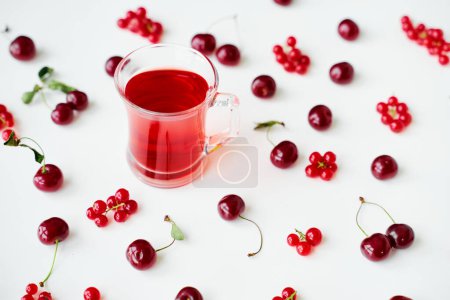 Photo for Glass cup of fruit tea on white backgrund with red berries. - Royalty Free Image