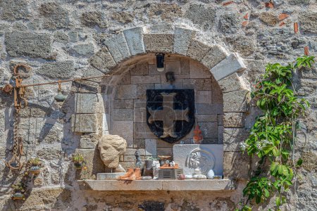 Photo for Greek decorative objects, made of stone and metal, with the insignia of the Knights of Ioannites, placed on a stone wall of a house on the island of Rhodes, in the old town of Rhodes. - Royalty Free Image
