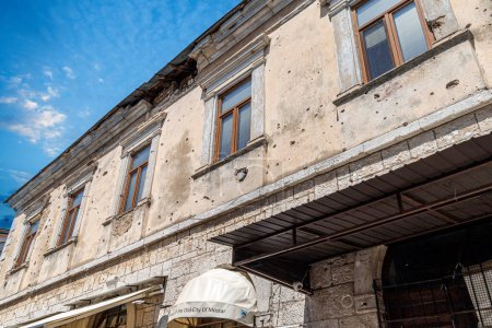 Foto de Bullet holes in a house facade of one abandoned building, caused by gunfire during Bosnian War (1992-1995), at Onescukova Street in Mostar city, Bosnia and Herzegovina. War Memory. - Imagen libre de derechos