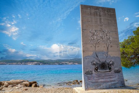 Téléchargez les photos : OREBIC, CROATIA - AUGUST 17, 2022: Concrete panel decorated with a graffiti artwork, on the European mainland shore, opposite the island of Korcula, Dalmatian coast. - en image libre de droit