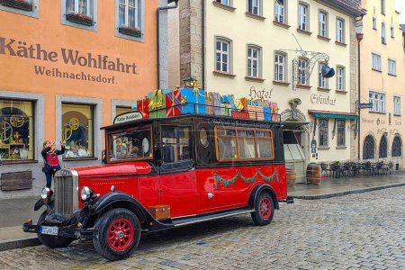 Foto de Rothenburg ob der Tauber, Baviera, Alemania - 1 de mayo de 2023: Coche de Santa vintage y divertido con regalos, en el casco antiguo medieval bien conservado, parte de la carretera romántica a través del sur de Alemania. - Imagen libre de derechos