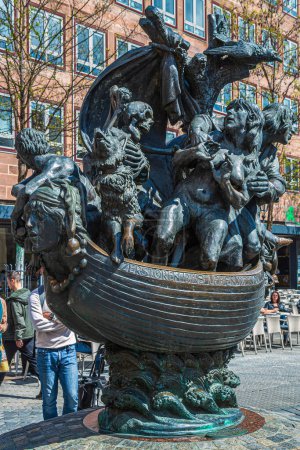 Photo for NUREMBERG, GERMANY-APRIL 30, 2023: Fountain of the Ship of Fools (Narrenschiffbrunnen), sculptor Jurgen Weber. The bronze sculpture shows a boat as a metaphor for the world threatened with extinction. - Royalty Free Image