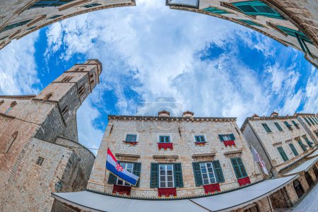 Photo for DUBROVNIK, CROATIA - AUGUST 14, 2022: Medieval buildings and Croatian flag on Stradun street limestone-paved pedestrian from the 13th century which runs some 300 metres through the Old Town. - Royalty Free Image