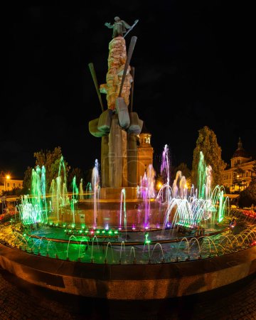 Téléchargez les photos : Cluj-Napoca, Roumanie - 5 octobre 2023 : La fontaine illuminée multicolore autour de la statue d'Avram Iancu, située sur la place du même nom. - en image libre de droit