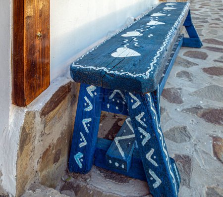The old wooden bench painted blue and decorated with traditional symbols specific to the Lipovan ethnic group from the Danube Delta area, Murighiol commune, Tulcea County, Dobrogea Region, Romania.
