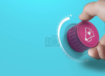 Foto de Man turning a pink knob with a megaphon icon. Brand communication strategy and advertising concept over blue background with copy space. - Imagen libre de derechos